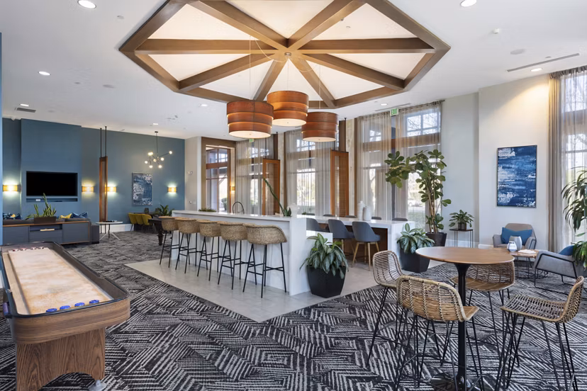 Modern clubhouse with cozy seating and large windows at Domicilio Apartments offering a welcoming ambiance for residents