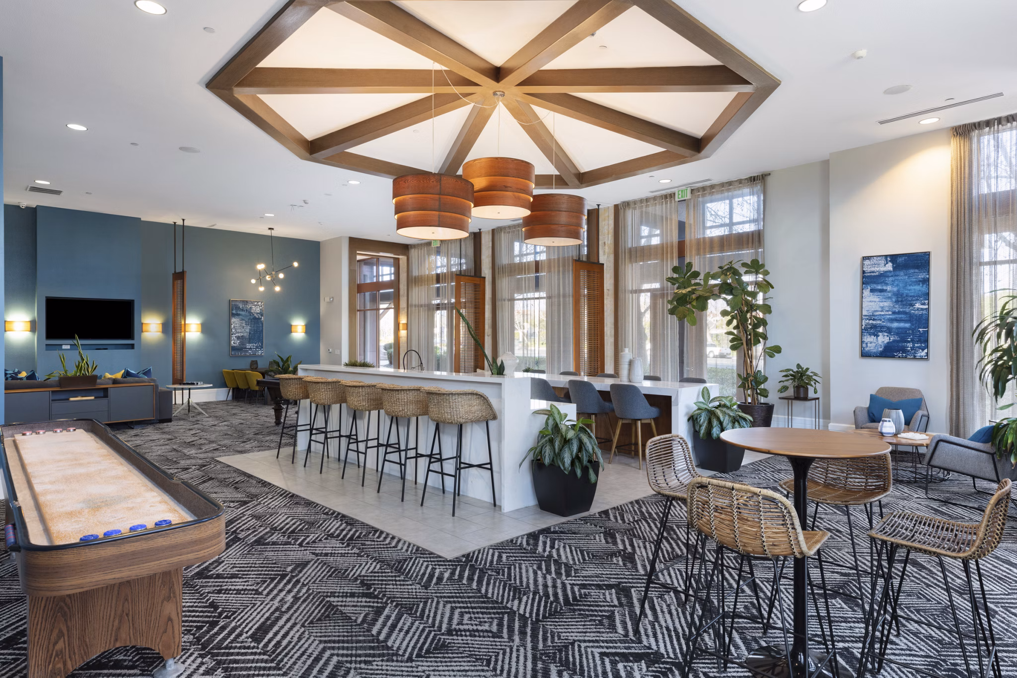 Modern clubhouse with cozy seating and large windows at Domicilio Apartments offering a welcoming ambiance for residents