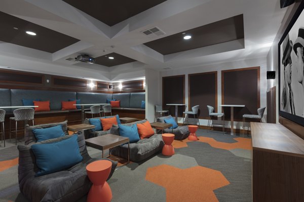 Domicilio Apartments: Modern theater room featuring plush seating and large screen for entertainment in Santa Clara