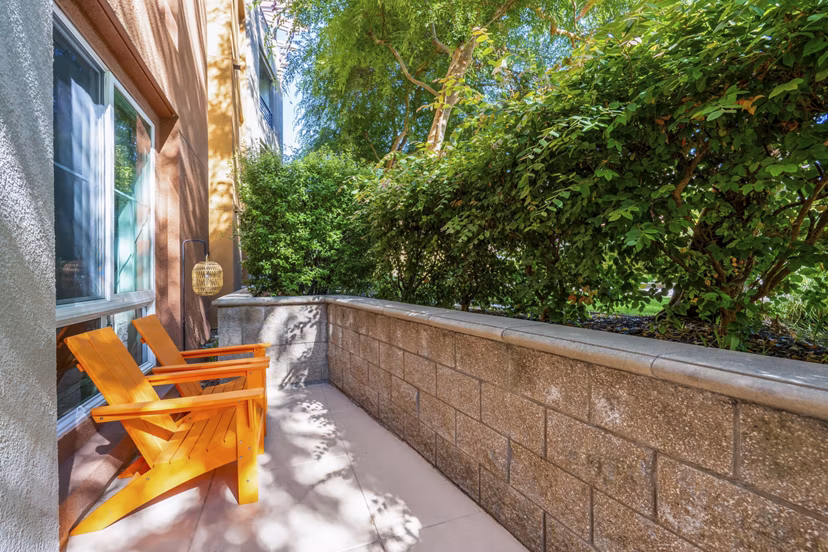 Patio with modern seating at Domicilio Apartments featuring lush greenery