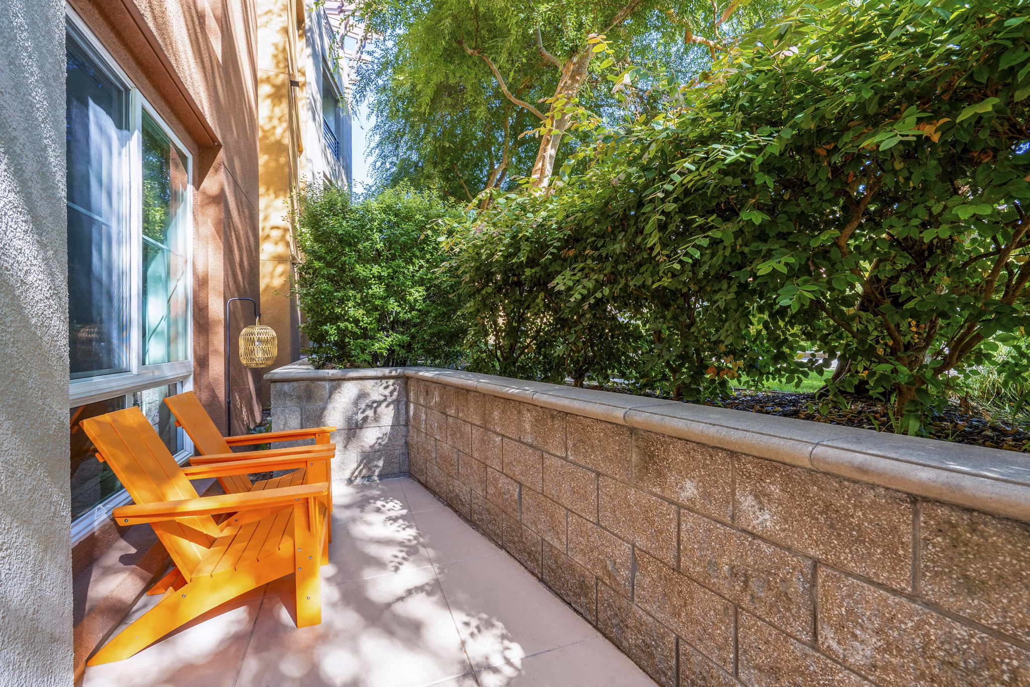 Patio with modern seating at Domicilio Apartments featuring lush greenery