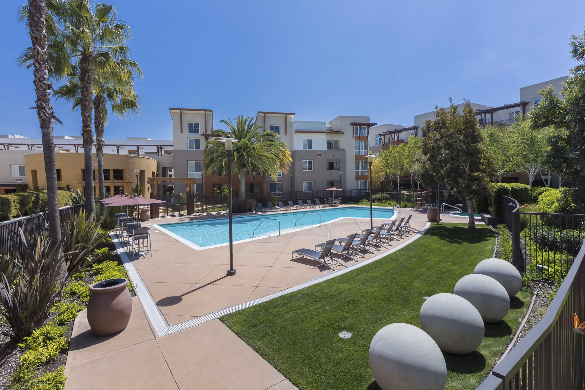 Luxurious pool with lounge chairs at Domicilio Apartments