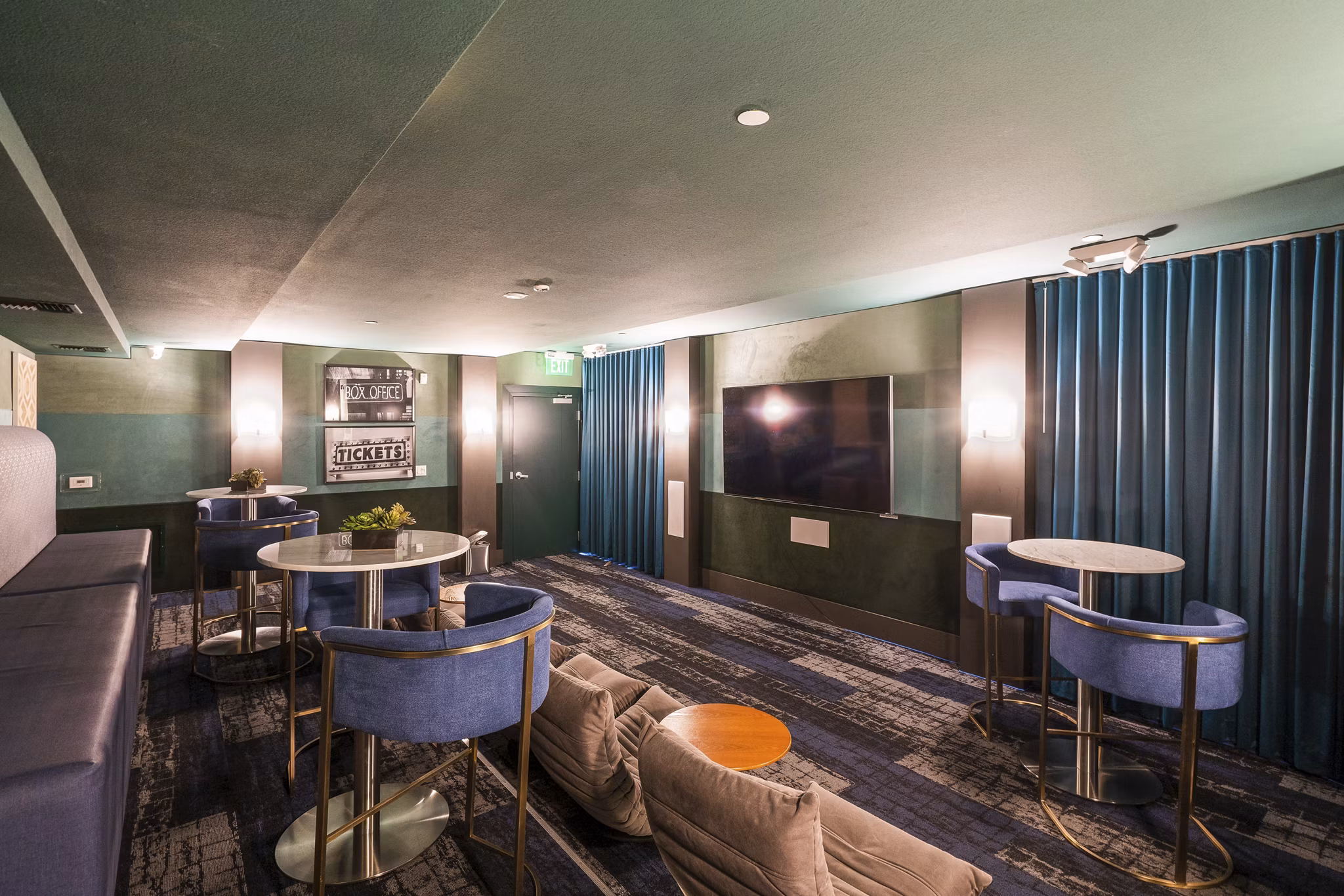 Elements Apartments: Modern theater room with comfortable seating and state-of-the-art screen for residents' entertainment