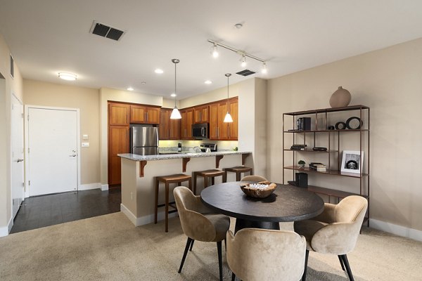 Dining area featuring modern furniture and natural light at Elements Apartments