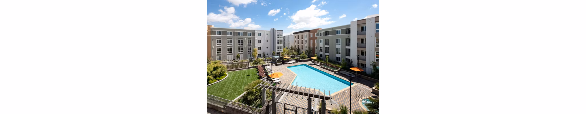 Outdoor pool area with sun loungers at Elements Apartments, offering relaxation and luxury living in a prime location