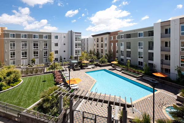 Outdoor pool area with sun loungers at Elements Apartments, offering relaxation and luxury living in a prime location