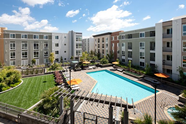 Outdoor pool area with sun loungers at Elements Apartments, offering relaxation and luxury living in a prime location
