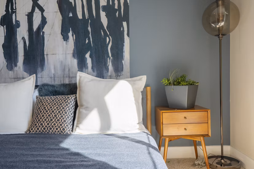 Cozy bedroom with modern decor at Mosaic Apartments, featuring soft lighting and stylish furnishings for a relaxing retreat