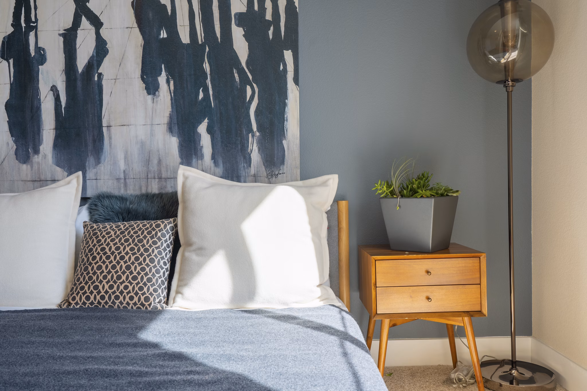 Cozy bedroom with modern decor at Mosaic Apartments, featuring soft lighting and stylish furnishings for a relaxing retreat