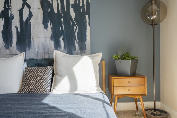 Cozy bedroom with modern decor at Mosaic Apartments, featuring soft lighting and stylish furnishings for a relaxing retreat