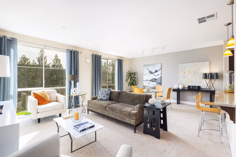 Living room with modern furnishings and natural light at Greystar's Mosaic Apartments