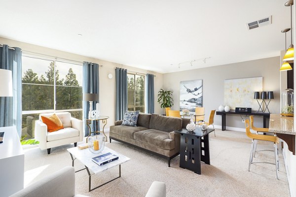Living room with modern furnishings and natural light at Greystar's Mosaic Apartments