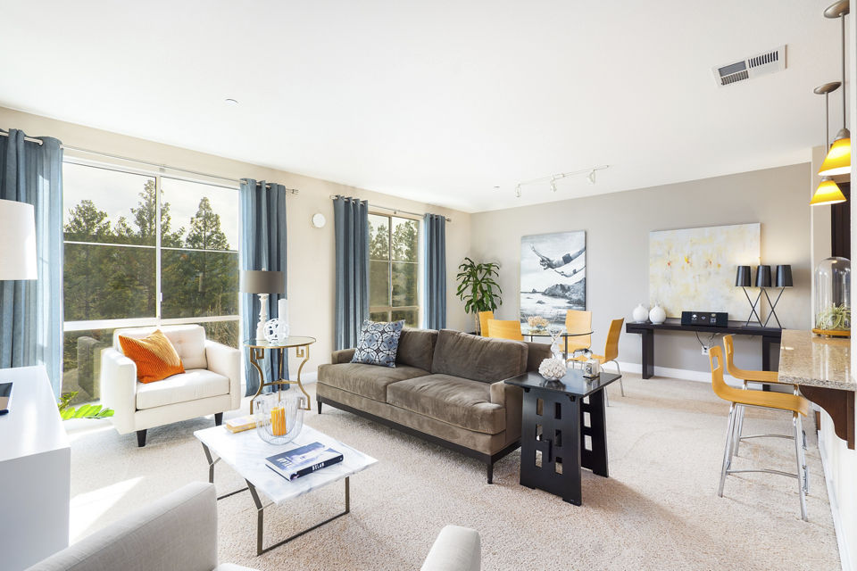 Living room with modern furnishings and natural light at Greystar's Mosaic Apartments