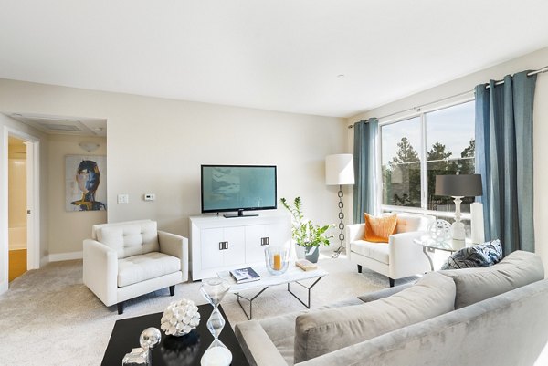 Modern living room with stylish decor and natural light at Mosaic Apartments