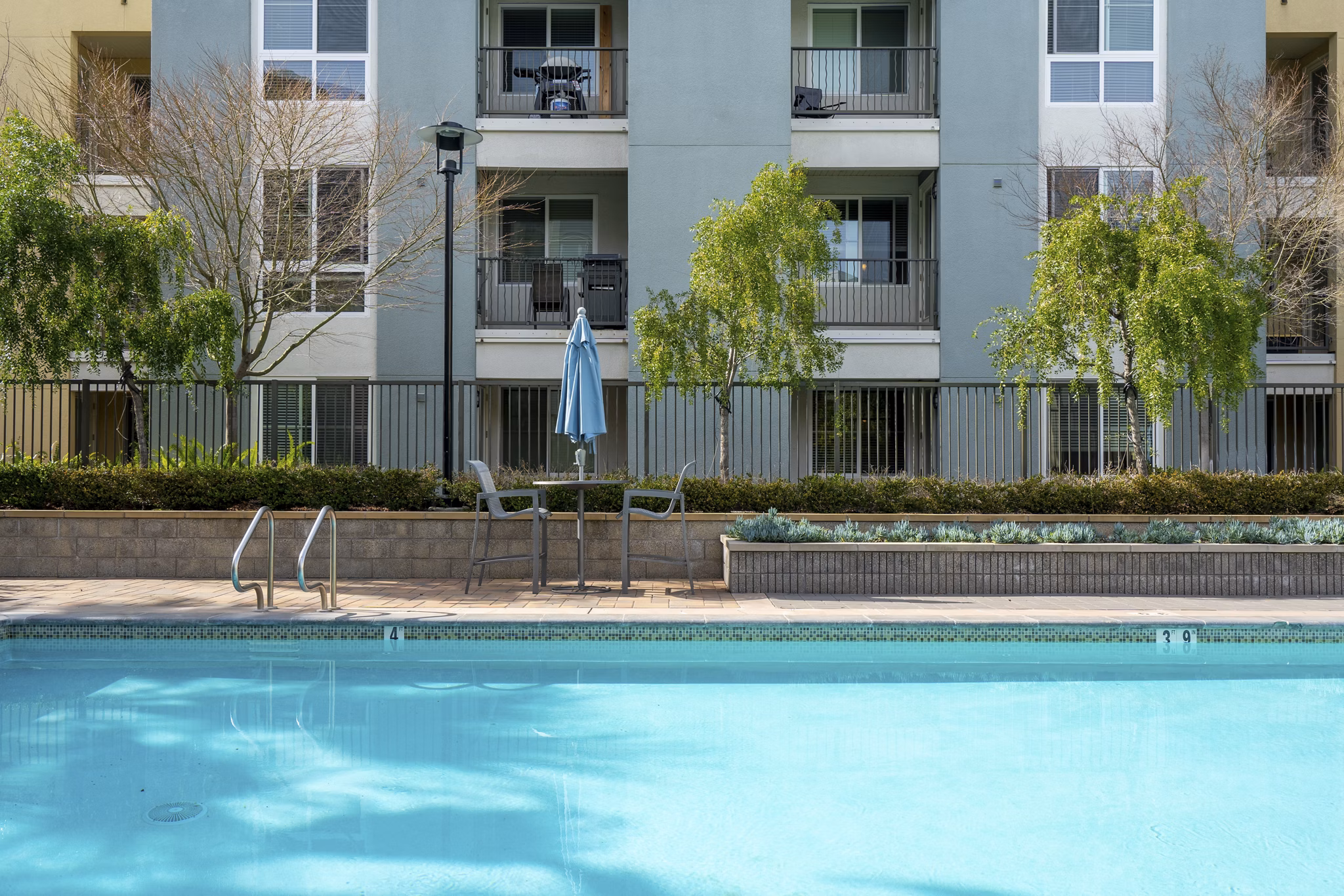 Resort-style pool with loungers at Mosaic Apartments, luxury living in prime urban location