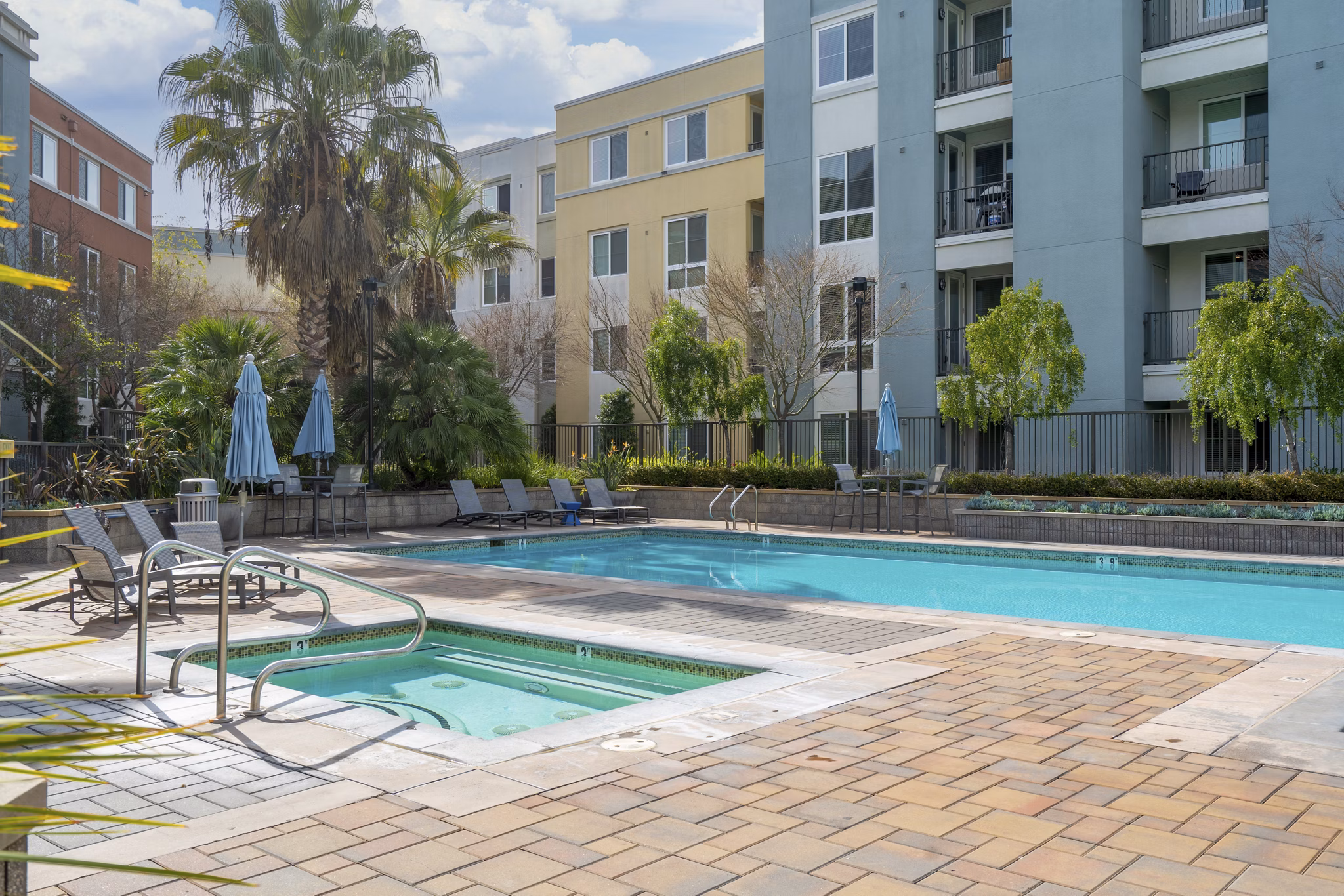 Modern outdoor pool with poolside seating at Mosaic Apartments, a Greystar luxury community
