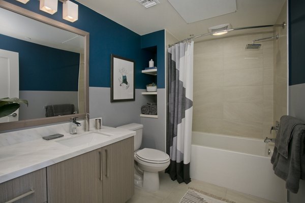 Modern bathroom with sleek fixtures and large mirror at Sway Apartments, a luxury apartment community by Greystar