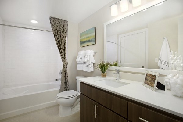 Bathroom featuring modern fixtures and large mirror at Broadstone on 9th Apartments