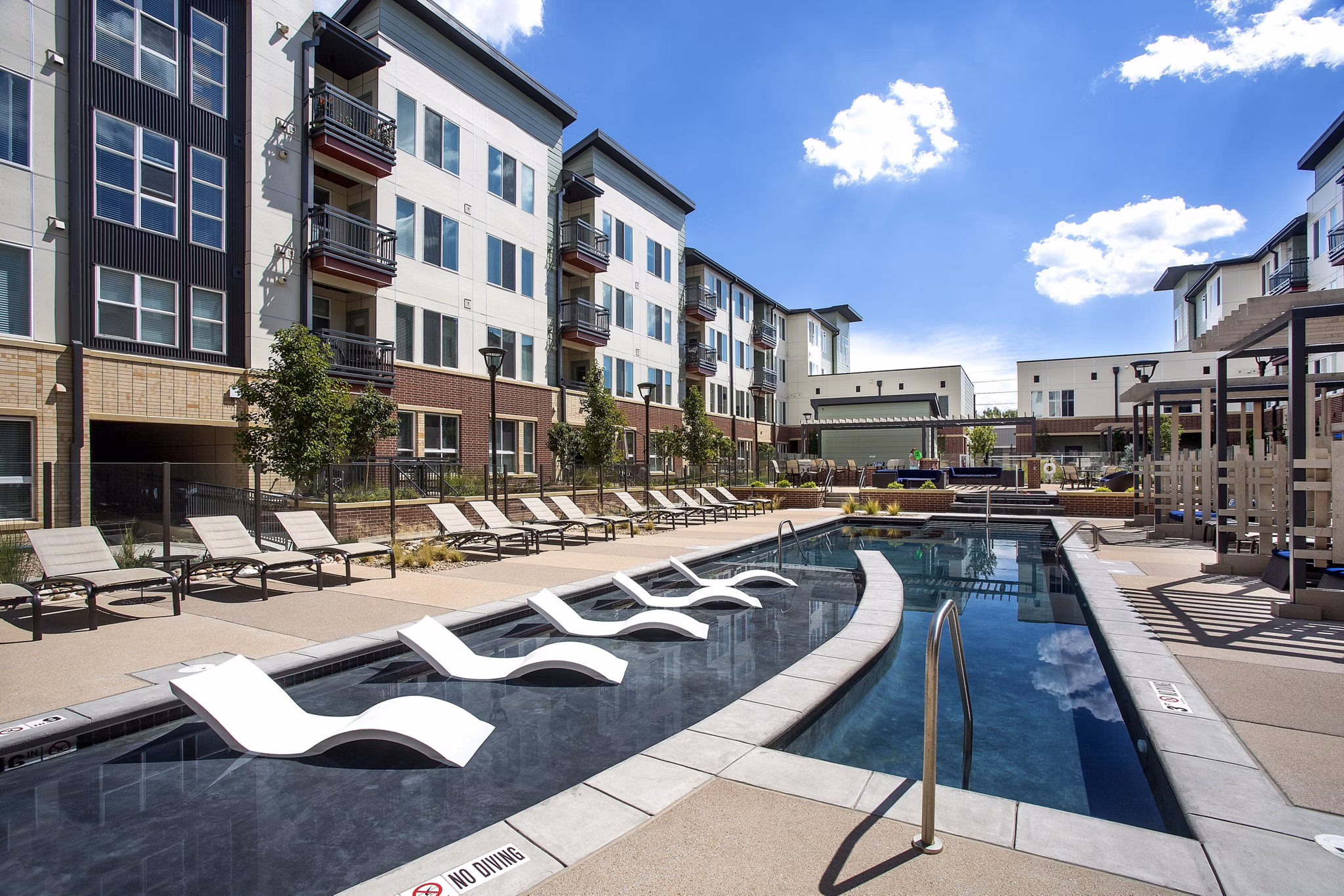 Luxury poolside relaxation at Broadstone on 9th Apartments, featuring modern design and lush surroundings