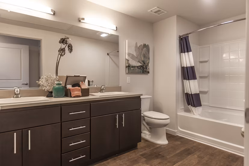 Modern bathroom with marble countertops and sleek fixtures at The Artisan Apartments