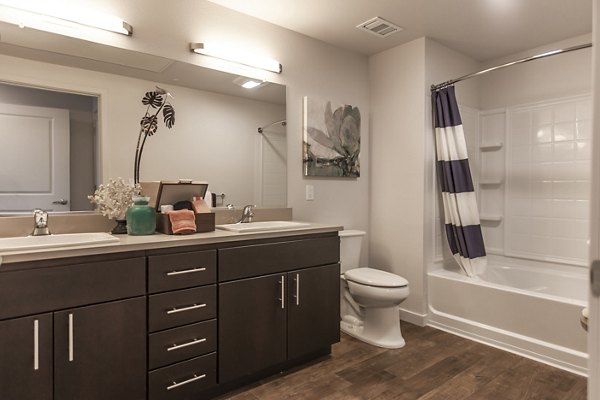 Modern bathroom with marble countertops and sleek fixtures at The Artisan Apartments
