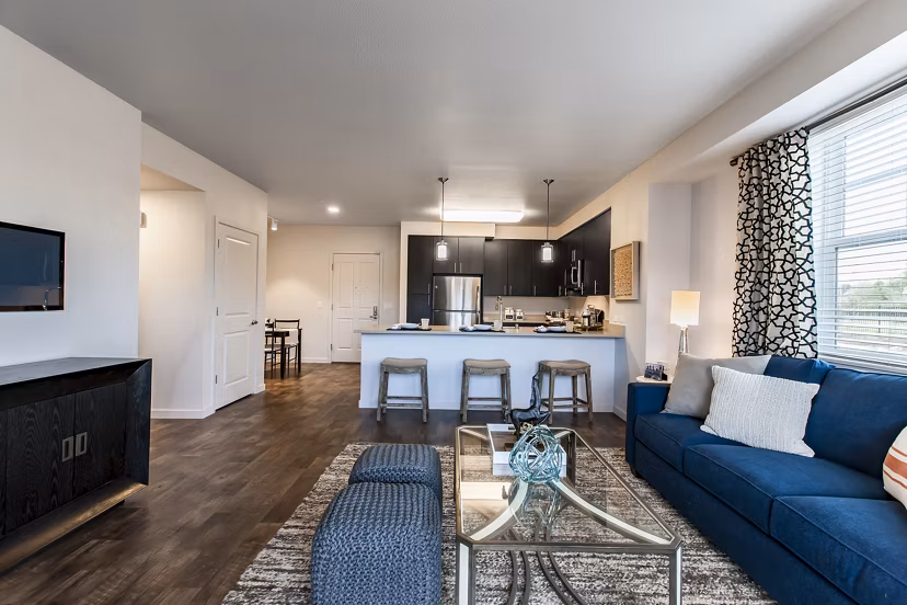 Living room with modern furnishings and natural light at The Artisan Apartments, luxury property by Greystar in a prime location
