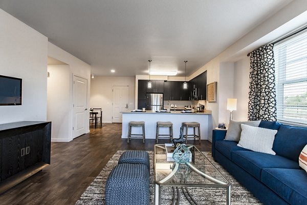 Living room with modern furnishings and natural light at The Artisan Apartments, luxury property by Greystar in a prime location