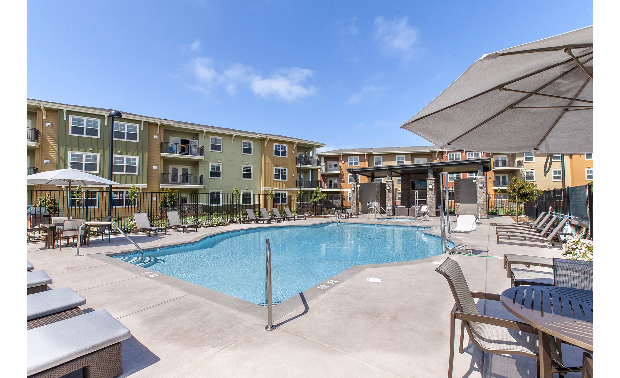 Peaceful outdoor pool at The Artisan Apartments with surrounding greenery