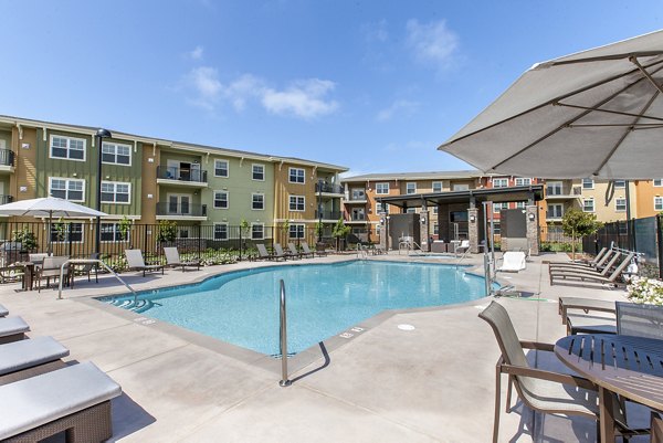 Peaceful outdoor pool at The Artisan Apartments with surrounding greenery