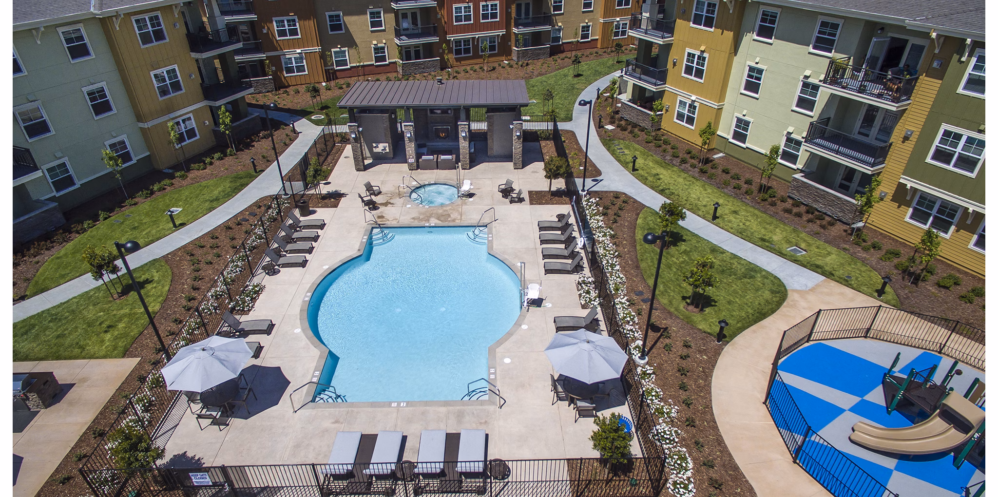 Luxurious pool with sun loungers at The Artisan Apartments, perfect for relaxation and leisure activities in a serene setting