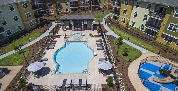 Luxurious pool with sun loungers at The Artisan Apartments, perfect for relaxation and leisure activities in a serene setting