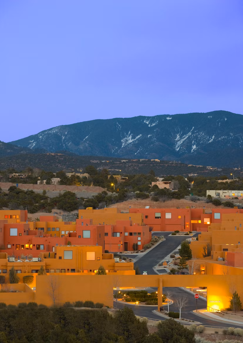 Colorful luxury apartments amidst a serene mountainous backdrop in a vibrant residential area