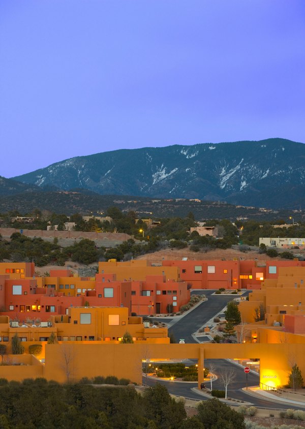 Colorful luxury apartments amidst a serene mountainous backdrop in a vibrant residential area