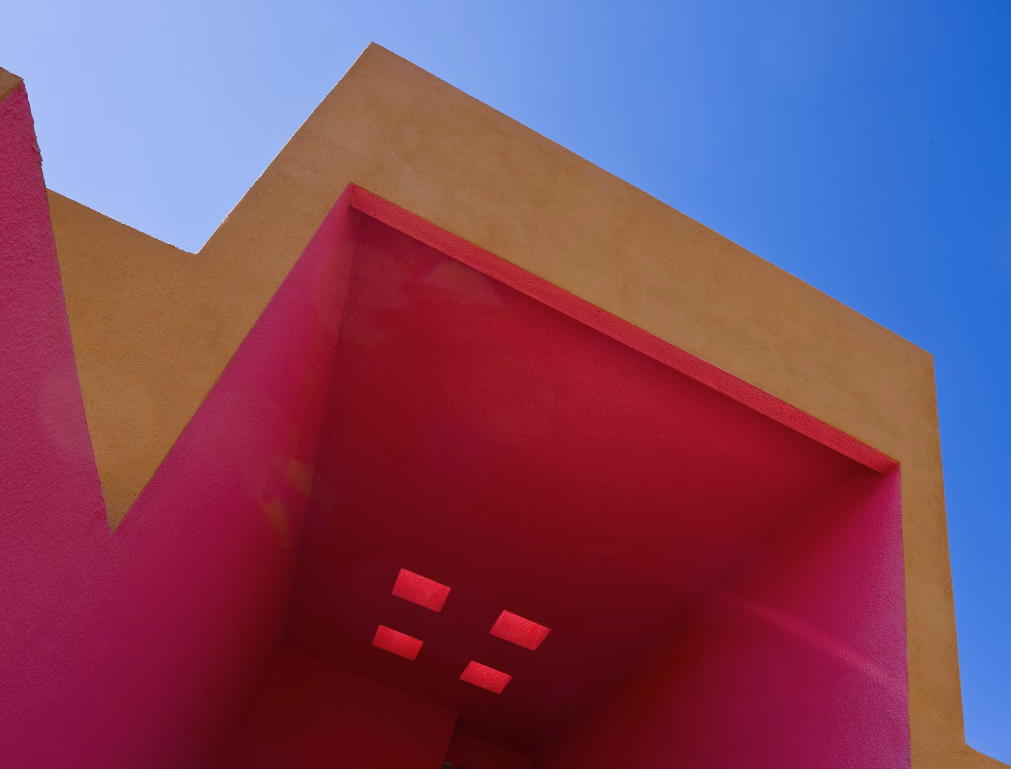 Colorful architectural structure with pink and orange walls in a vibrant urban setting