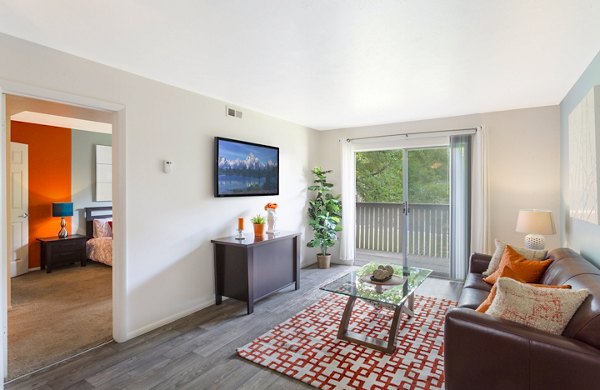 Cozy living room with modern furnishings and natural light at The Pointe at Northridge, luxury apartments by Greystar