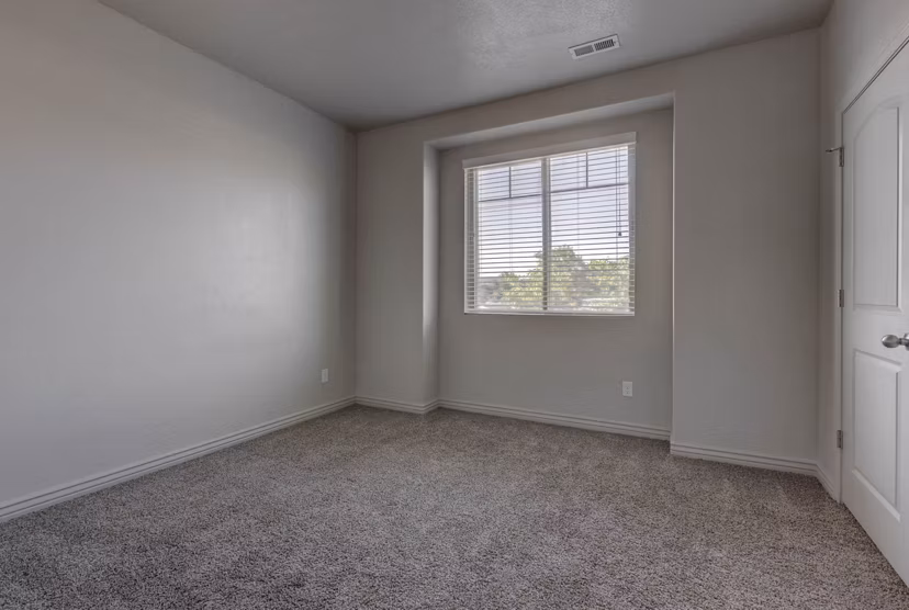 Spacious bedroom with contemporary furnishings at Villas on Main Apartments, offering luxury living options