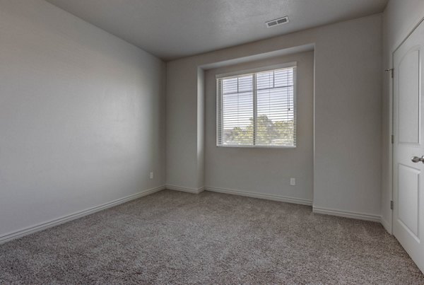 Spacious bedroom with contemporary furnishings at Villas on Main Apartments, offering luxury living options