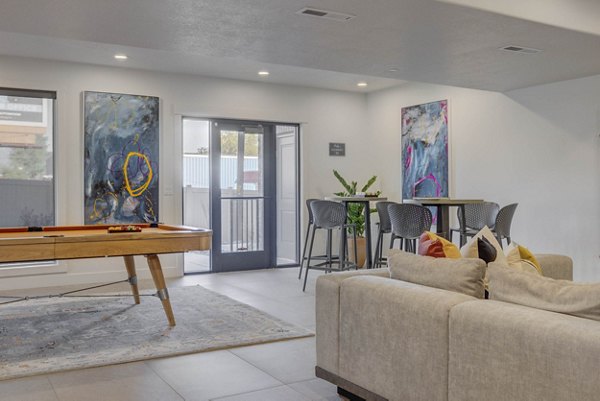 Game room featuring pool table and lounge seating at Villas on Main Apartments, perfect for relaxation and entertainment