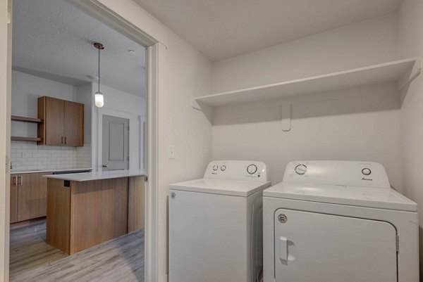 Modern laundry room with high-efficiency washers and dryers at Villas on Main Apartments