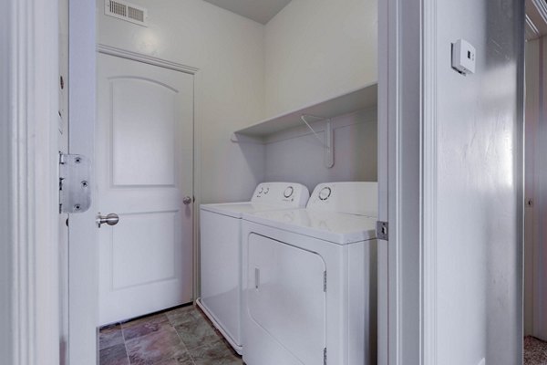 Laundry room with modern washers and dryers at Villas on Main Apartments