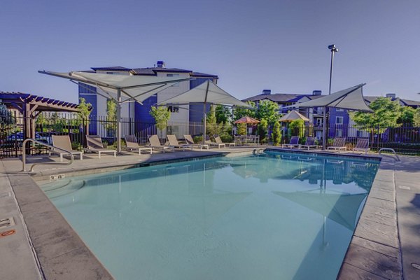Resort-style swimming pool with lounge chairs at Villas on Main Apartments