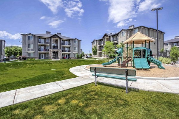 Children's playground with slides and swings at Villas on Main Apartments, ideal for family recreation and outdoor fun