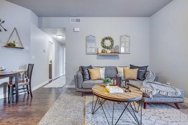 Spacious living room with contemporary decor and natural light at Pinnacle Highbury Apartments