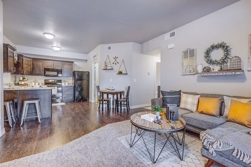 Bright living room with modern decor and large windows at Pinnacle Highbury Apartments
