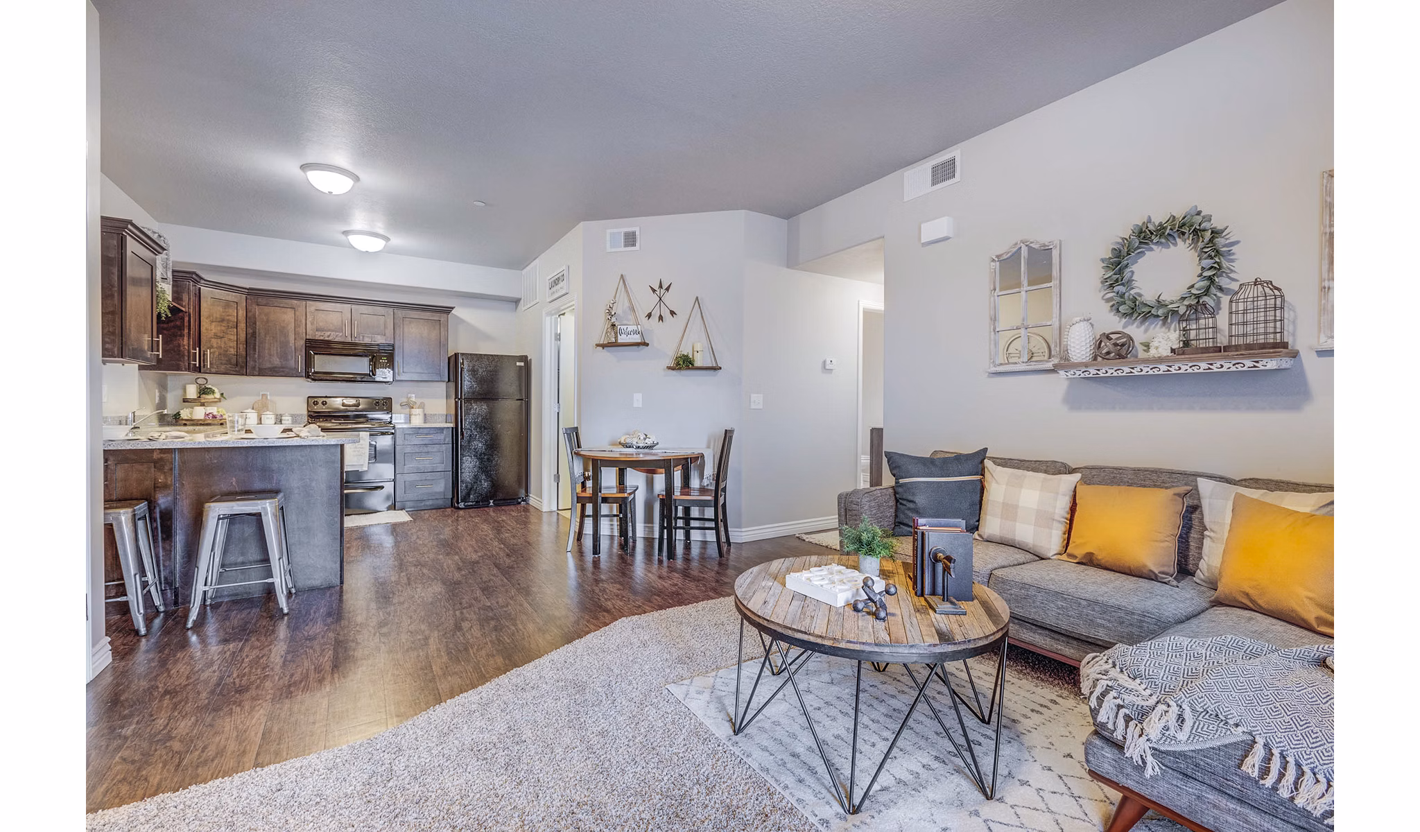 Bright living room with modern decor and large windows at Pinnacle Highbury Apartments