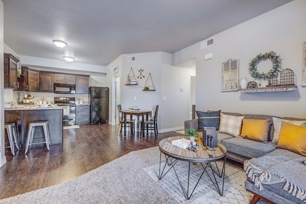 Bright living room with modern decor and large windows at Pinnacle Highbury Apartments