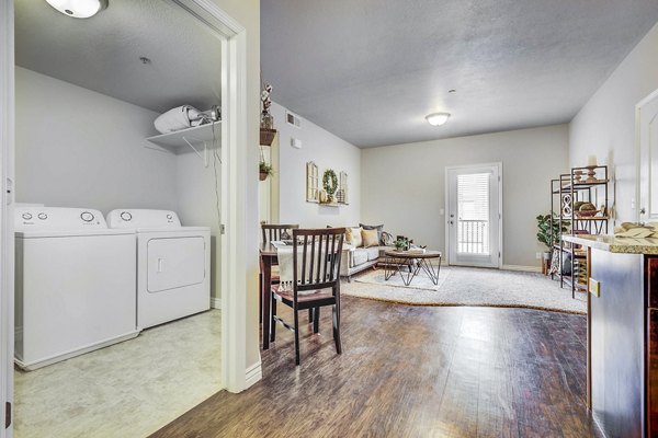 Laundry room with modern washers and dryers in Pinnacle Highbury Apartments, offering convenience and efficiency for all residents