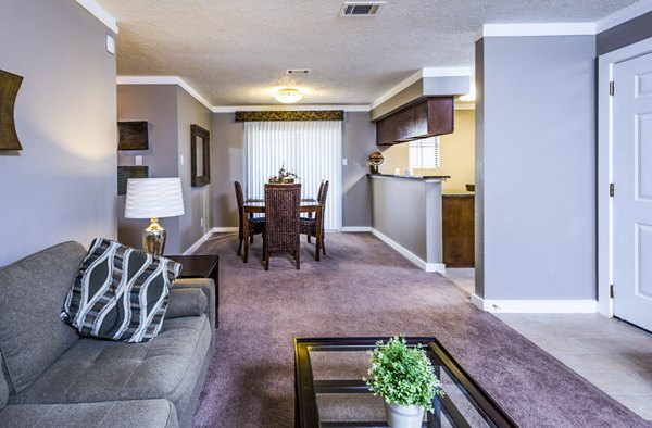 Modern living room with stylish decor at Fountainhead Apartments featuring a large sofa and wall art