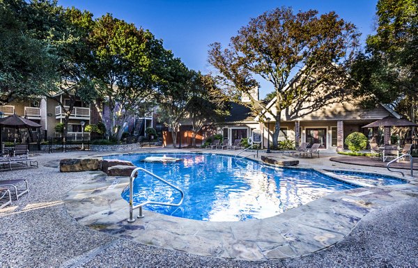 Relaxing outdoor pool area at Fountainhead Apartments with lush greenery