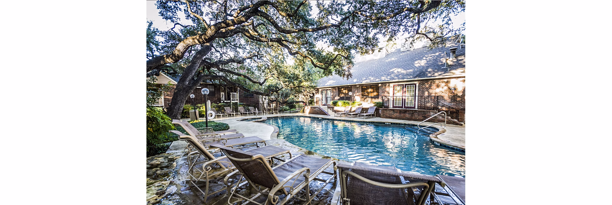 Luxurious poolside at Fountainhead Apartments with lounge chairs and scenic views